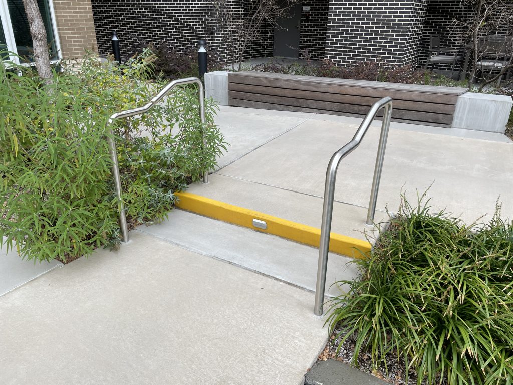 Elevation changes that meet accessibility provisions dictated by the ADA with handrails and painted nosing.